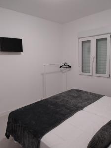 瓦伦西亚Apartamento Gran Turia的白色卧室设有一张大床和窗户