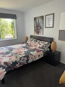 堪培拉Inner City Boutique Home. Pet and Family Friendly!的一间卧室配有一张带花卉床罩的床和窗户。