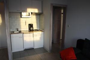 杜亨Haus Nordsee 06的小厨房配有白色橱柜和水槽