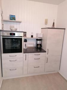 库克斯港Haus Kehrwieder Fewo 03的厨房配有白色橱柜和微波炉