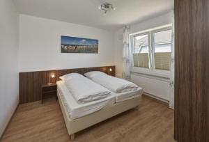 库克斯港Op de Geest 10的一间卧室设有一张床和一个窗口
