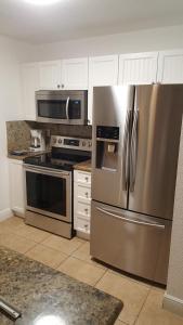 Bailey TownOcean Villa Supreme的厨房配有不锈钢冰箱和微波炉。