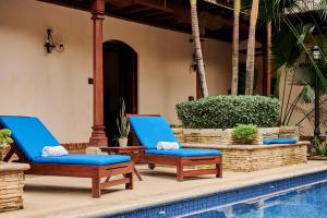 格拉纳达Hotel Plaza Colon - Granada Nicaragua的游泳池旁的一张蓝色躺椅