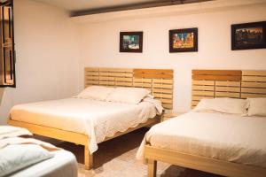圣罗莎德卡瓦尔Hotel Raíces Casona Real的卧室配有两张床,墙上挂有两张照片