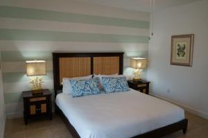 Bailey TownOcean Villa Supreme的一间卧室配有一张带蓝色枕头的床和两盏灯。
