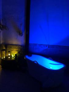 卡波布里奥Suíte Verão na Praia的深色客房内的蓝色浴缸