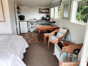 HaumoanaHaumoana Herb Cottage的一间小房子里的卧室,配有桌椅