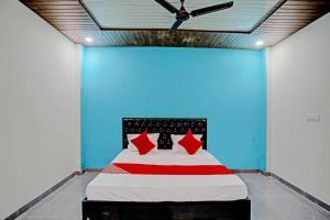 坎普尔The Cawnpore Inn的蓝色间内的一张带红色枕头的床