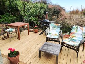 HaumoanaHaumoana Herb Cottage的庭院配有两把椅子、一张桌子和一张桌子