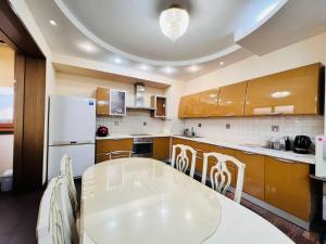 阿拉木图MegaTowers的厨房配有白色桌子和白色冰箱。