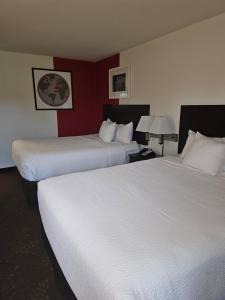 西塔科锡塔克华美达套房酒店的红色墙壁的酒店客房内的两张床
