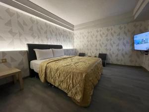 桃园市溫情自助旅店的一间卧室配有一张床和一台平面电视