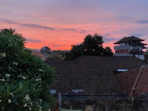 罗威那Kubu Elsa Bali的日落时分房屋屋顶的景色