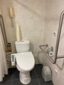 台北国王大饭店的一间带卫生间的浴室和墙上的一部电话