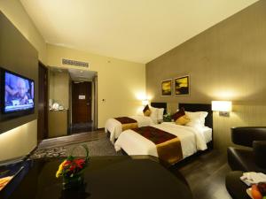 北赖槟城日光酒店的酒店客房设有两张床和一台平面电视。