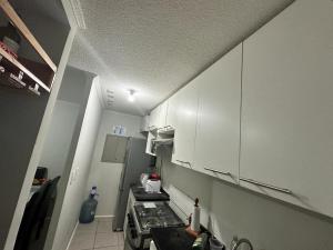 拉塞雷纳Frente a aeropuerto的小厨房配有白色橱柜和炉灶。