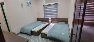 北宁Motel Xuân Hòa的带窗户的客房内设有两张单人床。