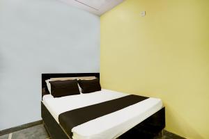 JhājharOYO Flagship Up13 Hotel的一间卧室配有一张带黑白床单和枕头的床。