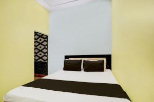 JhājharOYO Flagship Up13 Hotel的卧室配有白色床和棕色枕头
