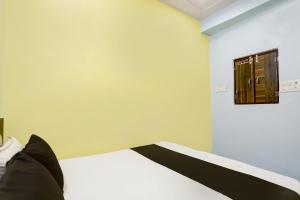 JhājharOYO Flagship Up13 Hotel的一间设有一张挂有墙上标志的床的房间