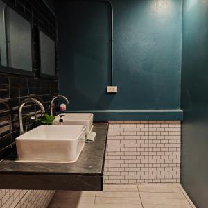 春蓬A lazy person hostel的浴室设有白色水槽和蓝色的墙壁