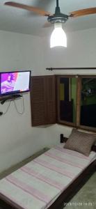 乌巴图巴Casa prática e completa próxima de tudo的卧室配有一张壁挂式平面电视的床。