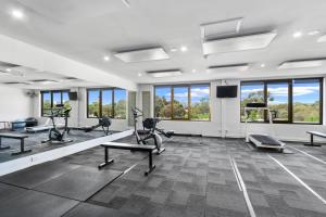 阿德莱德Comfort Hotel Adelaide Meridien的健身房设有跑步机、椭圆机和窗户