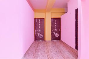 加尔各答The Blue Pearl Hotel的一条拥有紫色和黄色墙壁和木地板的走廊