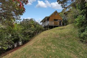 Cable BayMacrocarpa Cottage - Cable Bay Holiday Home的山顶上的木屋