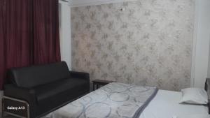 阿格拉HOTEL UDAY RAJ的一间卧室配有一张床和一张黑椅