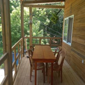 西区TOnat Caribe Hostel的小屋门廊上的木桌和椅子