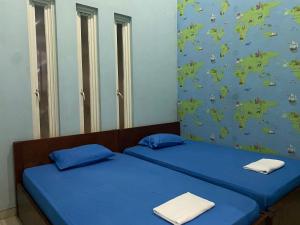 泗水The 8 House – Surabaya City Center的配有蓝色床单的客房内的两张床