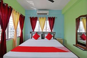 加尔各答The Blue Pearl Hotel的一间卧室设有一张红色和绿色的墙壁。