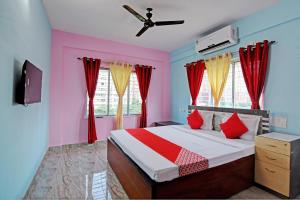 加尔各答The Blue Pearl Hotel的一间卧室设有一张红色和蓝色的墙壁床。