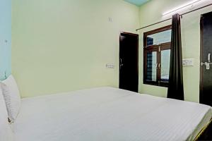 Garhi HarsāruOYO D Ekant Hotel的卧室配有白色的床和窗户。