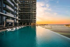 迪拜*Private Beach* Best Ocean View Emaar BeachFront的一座大楼前带椅子的游泳池