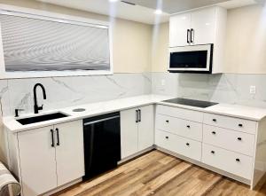 渥太华Home Advantage的厨房配有白色橱柜、水槽和微波炉