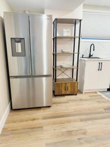 渥太华Home Advantage的厨房铺有木地板,配有不锈钢冰箱