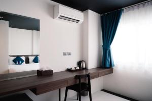 芭东海滩BearPacker Patong Hostel的一间卧室配有书桌和一张带镜子的床