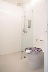 芭东海滩BearPacker Patong Hostel的带淋浴和卫生间的白色浴室