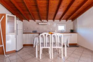 塞萨洛尼基Sunset rooftop apartment的厨房配有桌椅和冰箱。