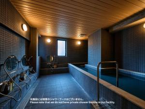东京Hotel Plus Hostel TOKYO ASAKUSA 2的浴室配有盥洗盆和浴缸。