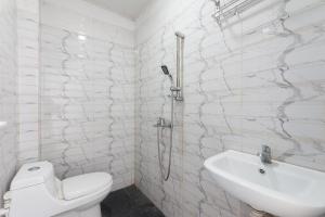 班达亚齐Urbanview Hotel Ranls Dream Banda Aceh by RedDoorz的浴室配有卫生间、盥洗盆和淋浴。