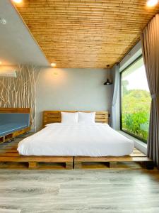 头顿Babylon Mini Resort的一间卧室设有一张大床和大窗户