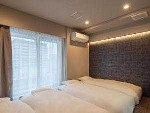 东京Hotel Plus Hostel TOKYO AKIHABARA的一间卧室设有两张床和窗户。