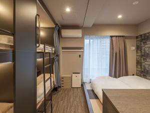 东京Hotel Plus Hostel TOKYO AKIHABARA的酒店客房设有两张床和窗户。