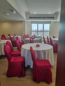 拜尔卡ALYA Hotel的一间会议室,配有桌子和红色椅子