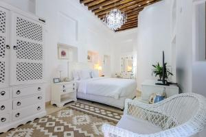 迪拜Arabian Boutique Hotel的白色卧室配有床和椅子