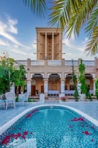 迪拜Arabian Boutique Hotel的一座带游泳池的度假村,位于一座建筑前