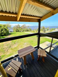 马拉库塔Ocean Breeze Tiny House - Ocean and Lake View的甲板上的长凳,享有田野的景色